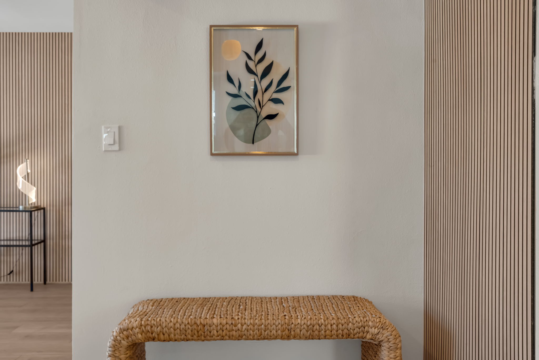 Hallway art and woven bench between rooms