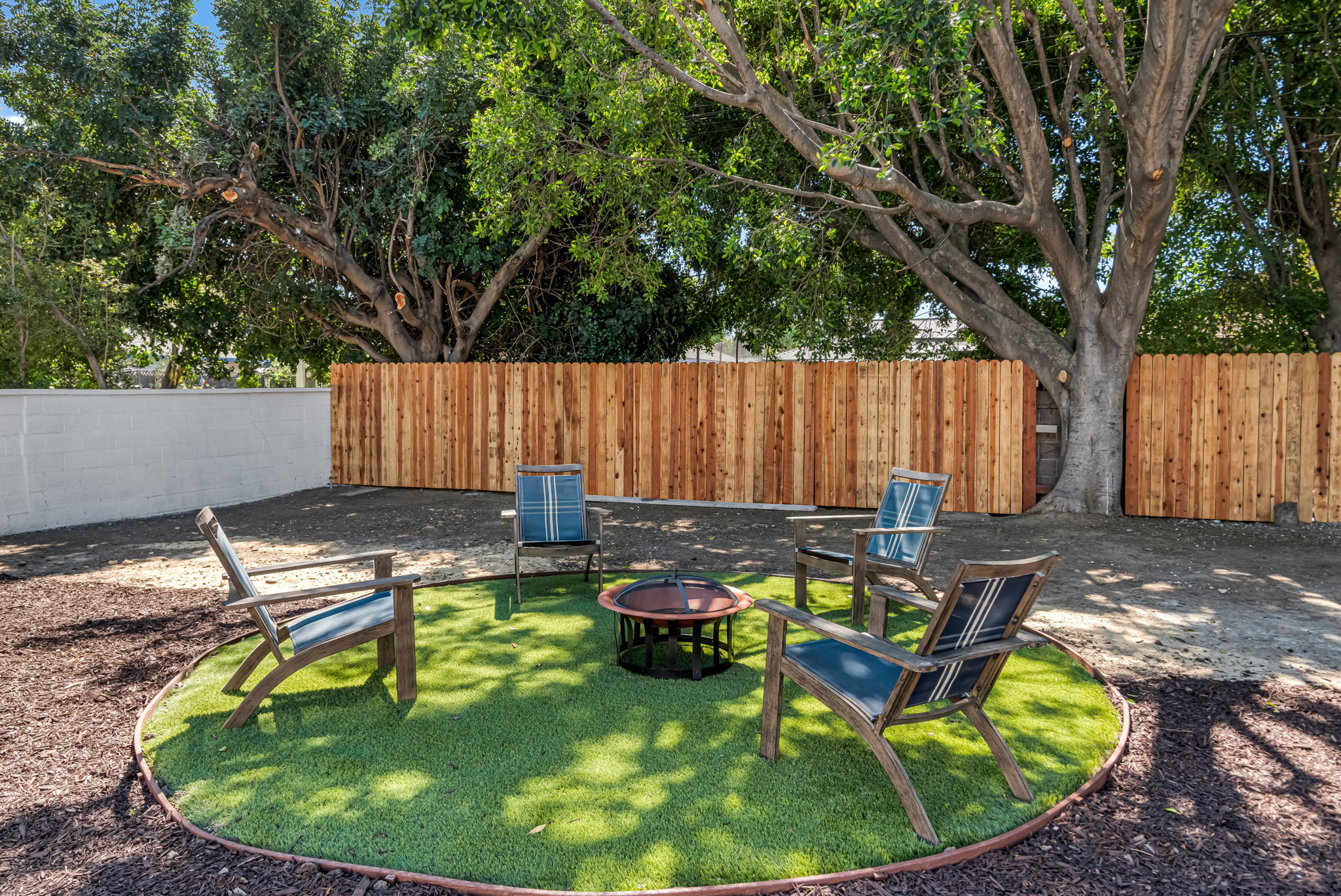 Backyard fire pit lounge on turf circle